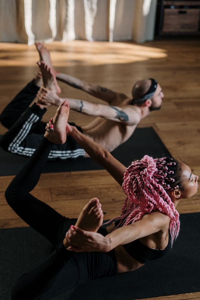 Offerings Yoga class with diverse individuals practicing together indoors, promoting wellness and fitness.