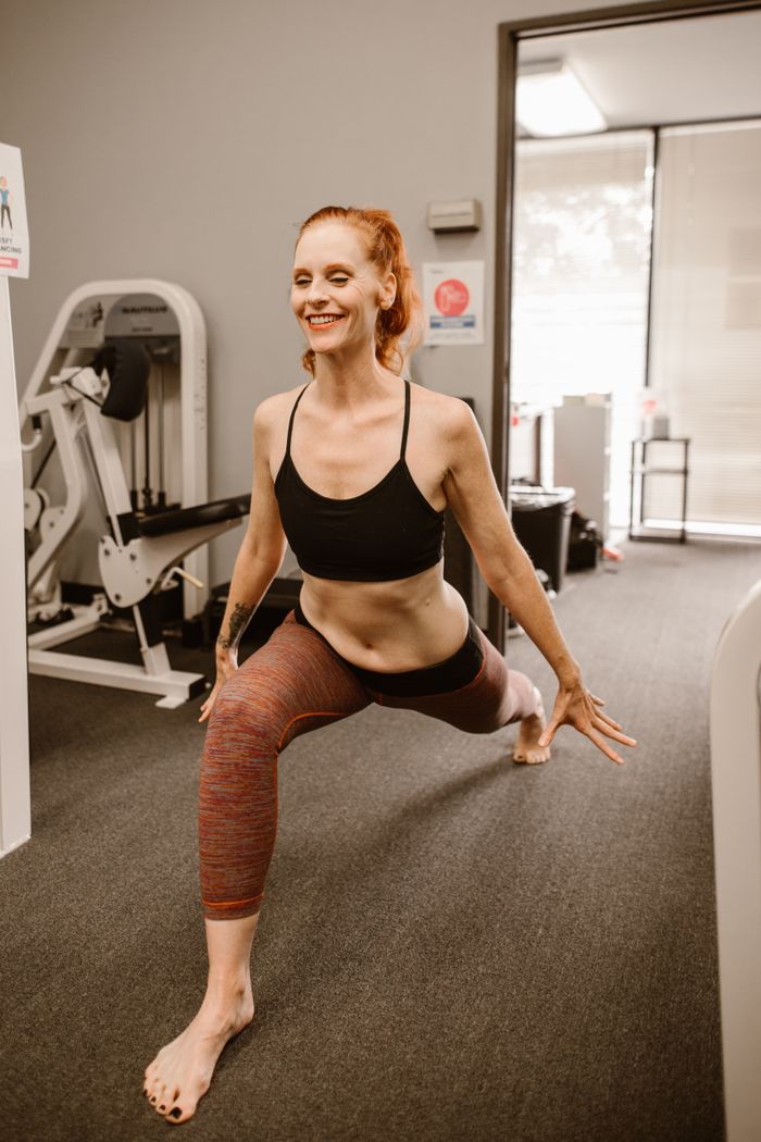 gallery-03 A woman performing yoga stretches in a fitness studio, enhancing wellness and flexibility.
